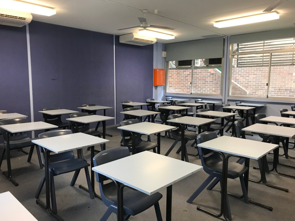 Photo of a classroom set up with individual desks apart.